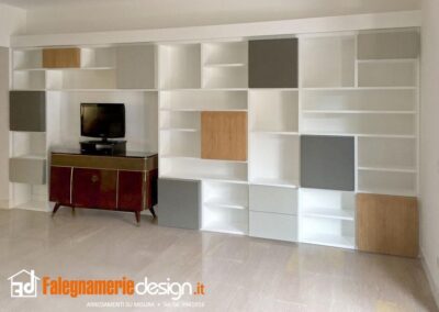 Soggiorno con libreria su misura composta da mensole e ante in legno