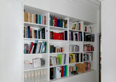 Corridoio con libreria su misura in legno incassata design moderno
