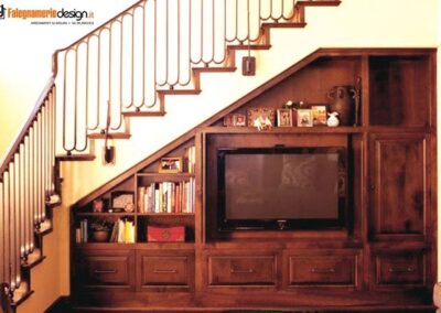 Soggiorno con mobile per tv nel sottoscala e parete attrezzata per libri