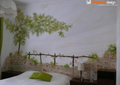 Camera da letto con parete interamente dipinta a mano libera