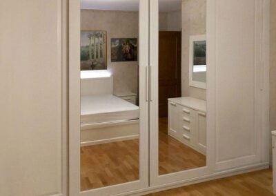 Camera da letto con armadio a muro in legno ed ante a specchio