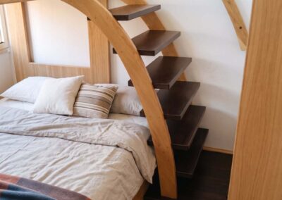 Letto a soppalco in legno di design con scala curva